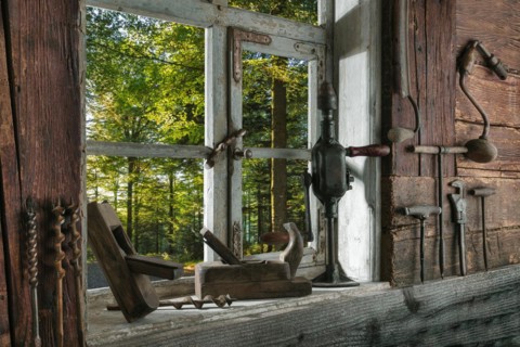 Rustic workshop with old tools and view out of the window into the forest