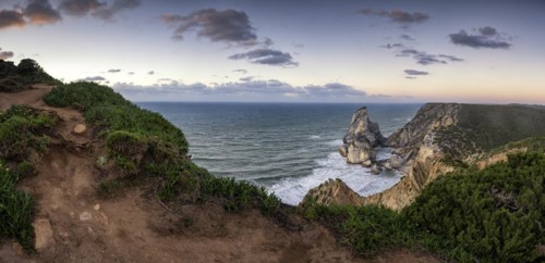 Sunset on the cliff with rocks in the sea