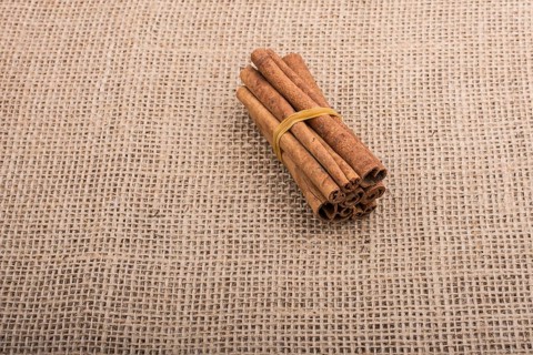 Bundle of cinnamon sticks on a linen canvas background