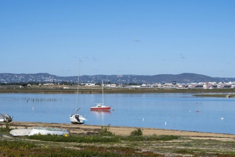 Fishing boats on the beach of the Ria Formosa nature park Park