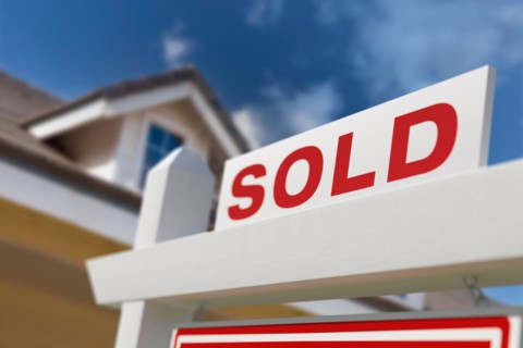 Sold for sale real estate sign in front of new house