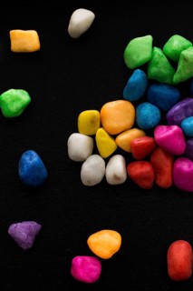 Pile of little colorful pebbles on black background
