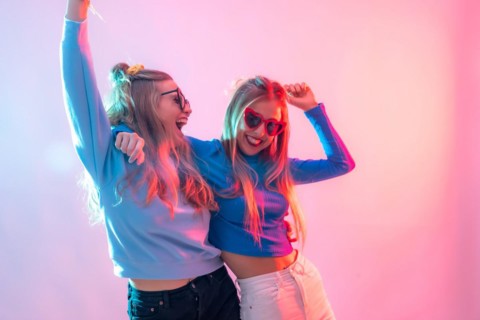 Two young blonde caucasian women dancing in disco