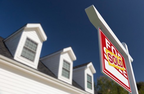 Sold for sale real estate sign in front of new house