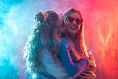 Two young blonde caucasian women dancing in disco