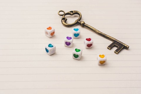 Key and colorful cubes with a heart placed on paper