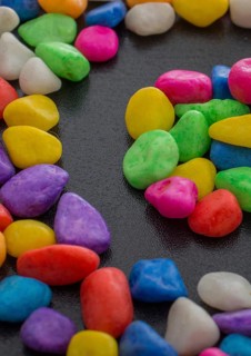Pile of little colorful pebbles on black background