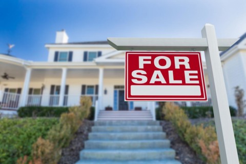 For sale real estate sign in front of new house