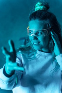 Woman with futuristic glasses gesturing against a blue background