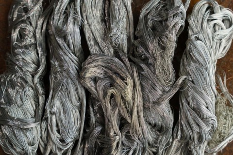 Silver metal copper wire scrap materials recycling of waste from manual wire tearing. Closeup of copper waste in the form of copper wires