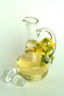 Rapeseed oil in a carafe with rapeseed flower