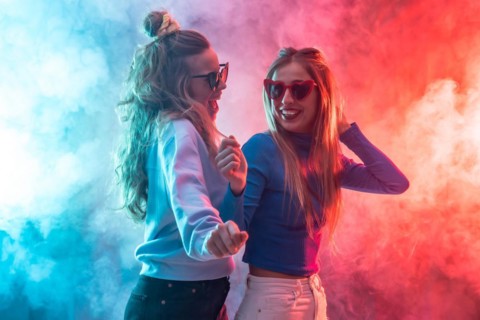 Two young blonde caucasian women dancing in nightclub