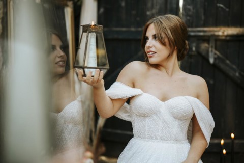Portrait of beautiful bride holding lantern in rustic background