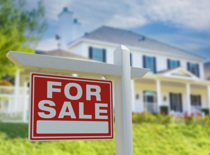 For sale real estate sign in front of new house