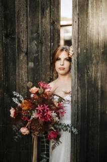 Beautiful bride with a bouquet with wooden door background as a background