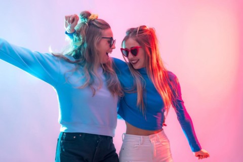 Two young blonde caucasian women dancing in disco