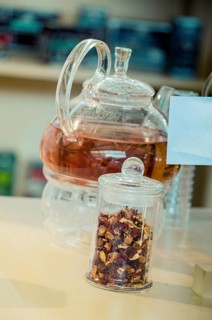 Herbal tea brewed in glass teapot and tea plant in a bottle