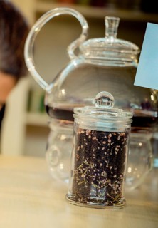 Herbal tea brewed in glass teapot and tea plant in a bottle