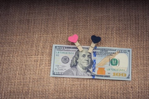 Heart icon bundle of US dollar placed on a linen canvas