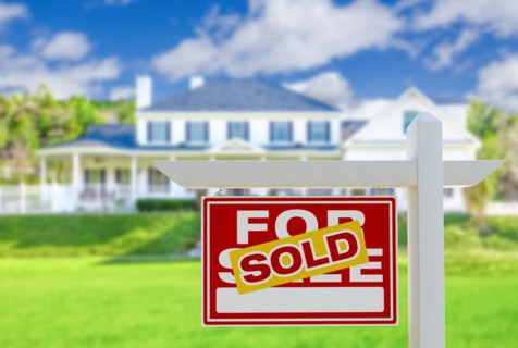 Sold for sale real estate sign in front of new house