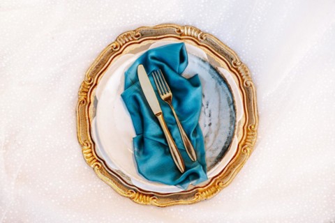 Golden and blue elegant table set on wedding dress
