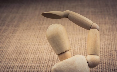 Wooden dolls of a man posing on canvas