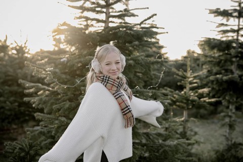 Teenage girl in front of fir trees