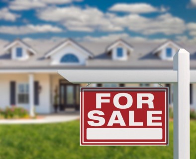 For sale real estate sign in front of new house