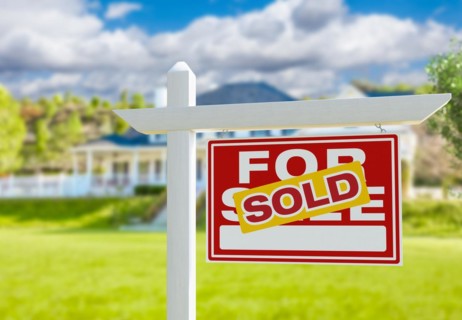 Sold for sale real estate sign in front of new house
