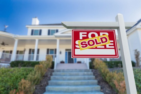 Sold for sale real estate sign in front of new house