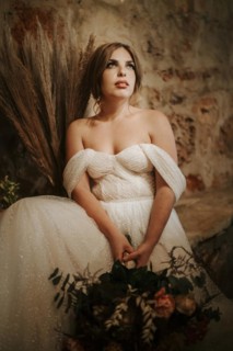 Portrait of beautiful bride with a bouquet in rustic settings