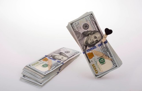 American 100 dollar banknotes with a heart clip on a string