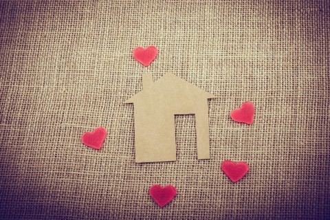 Heart shape around the paper house with a canvas background