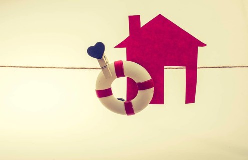 Model house and a life preserver with a heart on a string