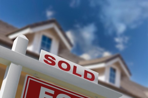 Sold for sale real estate sign in front of new house