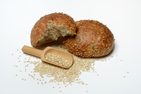 Roll covered with quinoa and scoop with quinoa seeds
