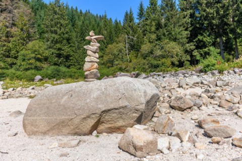 Pyramid of stones on a rock by a mountain lake. Vosges