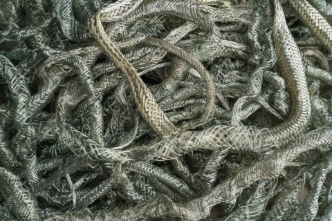 Silver metal copper wire scrap materials recycling of waste from manual wire tearing. Closeup of copper waste in the form of copper wires