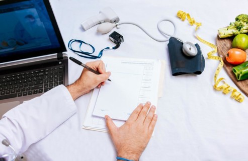 Top view of nutritionist writing on notepad. Concept of nutritionist taking notes on prescription