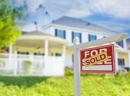 Sold for sale real estate sign in front of new house