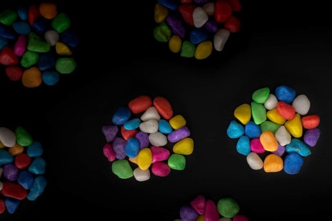 Pile of little colorful pebbles on black background