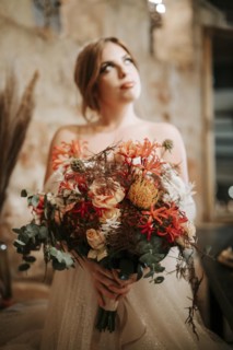 Portrait of beautiful bride with a bouquet in rustic settings