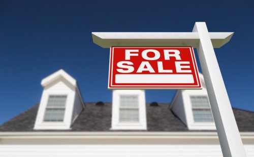 For sale real estate sign in front of new house