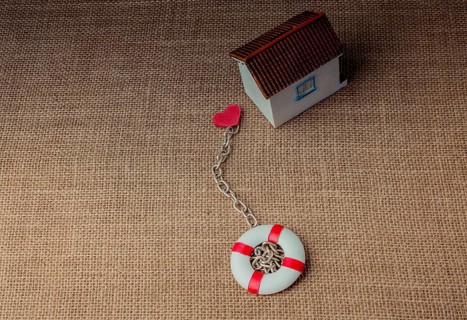 Model house and a life preserver with a heart on a chain