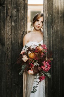 Beautiful bride with a bouquet with wooden door background as a background