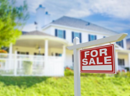 For sale real estate sign in front of new house