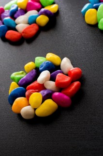 Pile of little colorful pebbles on black background