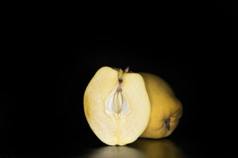 A halved and whole quince