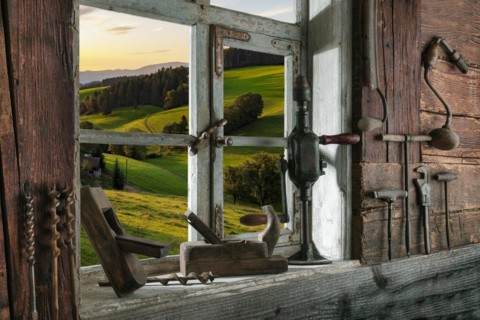 Rustic workshop with old tools and view out of the window into the landscape