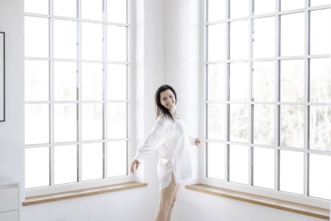 Attractive woman in a white shirt in front of a window